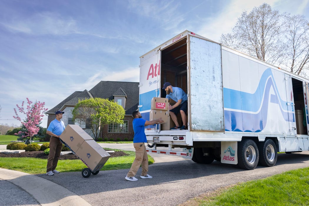 Atlas professionals packing boxes into moving truck for long distance move.